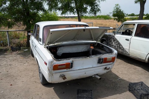 Car parked on a dusty road with the boot open, driving without a licence plate, Armenia
