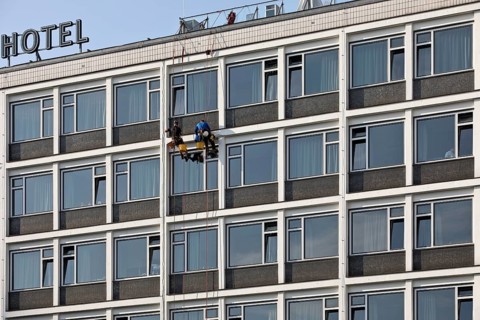 Two male glass cleaners abseiling down the hotel façade to clean windows, aletto Hotel Kudamm,