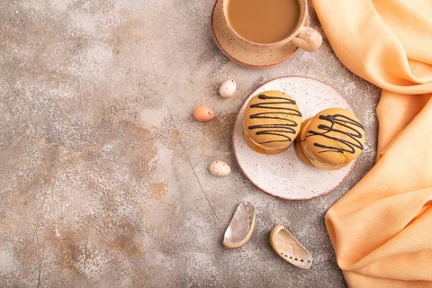 Caramel Cream Cakes on brown concrete background, cup of coffee, top view, flat lay, copy space