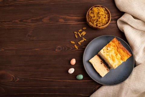 ?ottage cheese ?asserole, Curd cake, with dried apricots and raisins on brown wooden background and