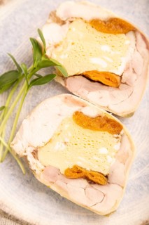 Chicken, egg and dried apricot meatloaf, microgreen on brown concrete background and linen textile.
