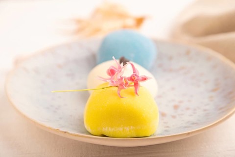 Japanese Mochi Cakes on white wooden background and linen textile, side view, close up, selective