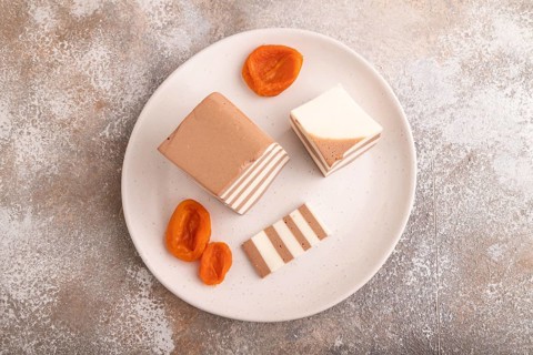 Cocoa and milk jelly with dried apricots on brown concrete background, top view, flat lay, copy