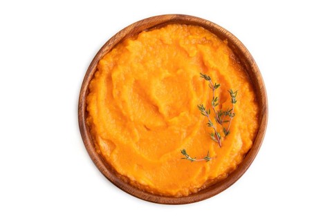 Sweet potato porridge in wooden bowl isolated on white background. Diet, healthy eating concept.