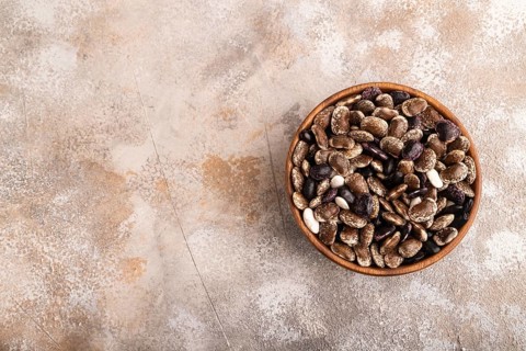 Wooden bowl with Kidney beans on brown concrete background, top view, flat lay, copy space,