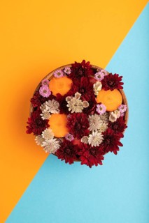 Wooden bowl with carrot slices and red Chrysanthemum flowers, Astrantia flowers, flower salad on