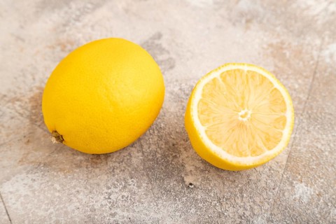 Yellow Lemon Cut in half on brown concrete background. Side view, close up, healthy food,