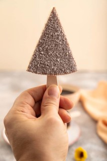 Chocolate and Vanilla Cake pops Marshmallow with hand with cup of coffee on brown concrete