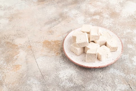 Coffee marshmallow on brown concrete background. side view, copy space