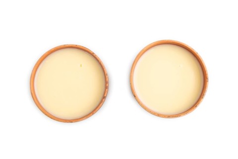 Organic non dairy banana and soy milk in clay cup isolated on white background. Vegan healthy food