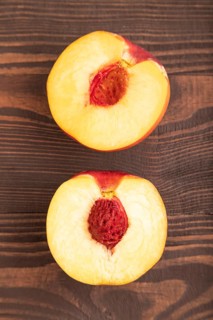 Peach Cut in half on brown wooden background. Top view, flat lay, close up. healthy food,