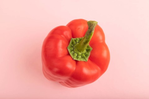 Red pepper on pink pastel background. Top view, flat lay, copy space. healthy food, vegetable,