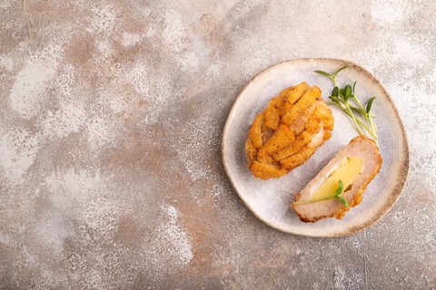 Chicken schnitzel on blue plate with microgreen on brown concrete. Diet, healthy eating. top view,