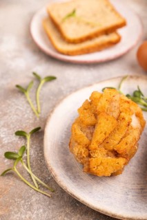 Chicken Schnitzel on blue plate with microgreen on brown concrete background and orange linen