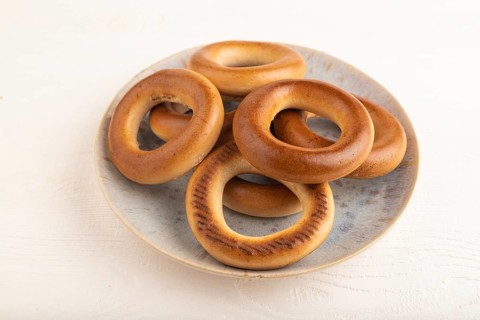 Homemade Ring Bagel on white wooden background. side view, close up