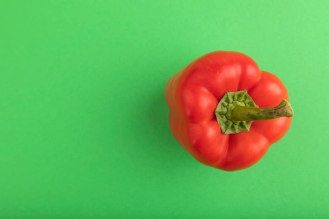 Red pepper on green pastel background. Top view, flat lay, copy space. healthy food, vegetable,