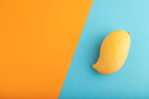 Orange mango on orange and blue paper pastel background. Top view, flat lay, copy space. healthy