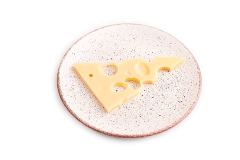 Piece of cheese with holes on plate isolated on white background, side view, copy space, minimalism