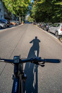 Cycling in the city, city centre street, shadow of the biker, cyclist perspective, Essen, North