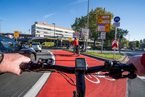 Riding a bike in a bike lane, marked in red to attract the attention of motorists, between 2 lanes,