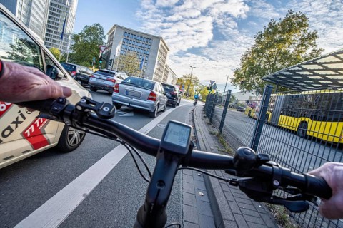 Riding a bike on a bike lane, at Essen main station, in front of Europaplatz, in the city centre of