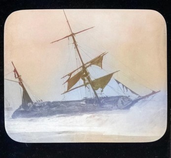 Shipwreck of wooden sailing ship on beach in stormy sea, location unspecified, c 1900 colourised