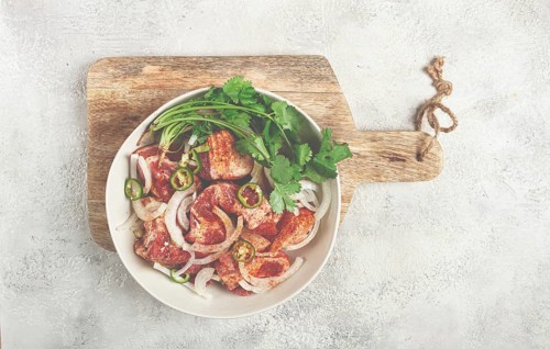 Raw meat marinated with spices and onions, for barbecue, sliced meat, pork neck, in a bowl,