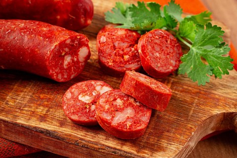 Spicy Chorizo sausage, on a cutting board, on a wooden table