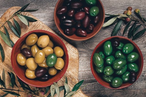 A mixture of olives, varieties of chalkidiki, Verdi giganti and Kalamata, in a bowl, top view, no