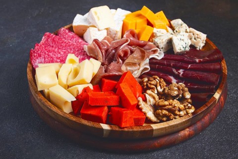 Assortment of cheese meat cuts, on a plate, top view, no people