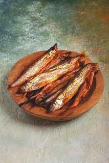 Cold smoked capelin, on a wooden bowl, top view, no people
