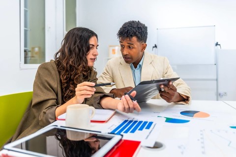 Diverse business colleagues discussing financial data and charts during an office meeting,