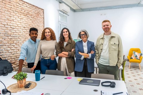Group of multi ethnic business people posing together in a bright, contemporary office space,