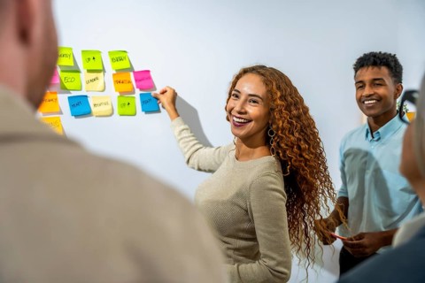 Young diverse business professionals collaborating, smiling, and brainstorming creative solutions