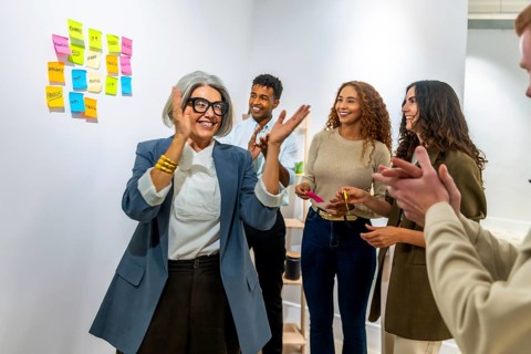 Diverse business team clapping hands, celebrating a successful achievement or project in a modern