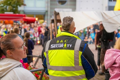 A security guard monitors the event amidst a crowd of visitors at the city festival, Feuernacht,