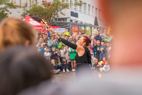Artist raises torches in the air while many people watch with excitement, Fire Night, Sindelfingen,