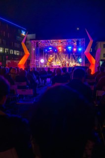 Concert at night on a colourfully illuminated open-air stage with audience, Feuernacht,