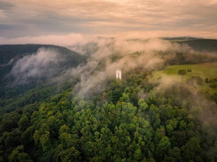 Fog envelops tower and forests, morning mood creates a peaceful atmosphere, Schönberg Tower,