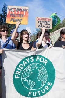 Young demonstrators with signs Welt brennt, Politik pennt und Gasausstieg: 2025 in front of the