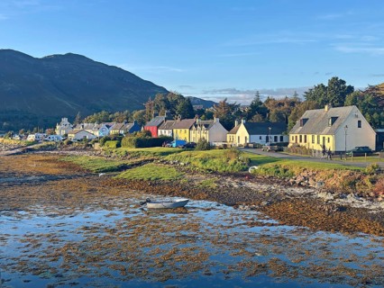 Coastal landscape with charming colourful houses and a small boat in the evening light, Dornie,