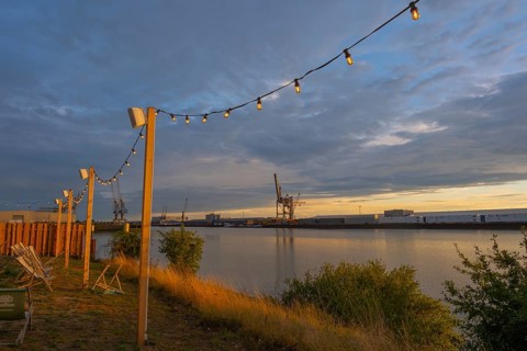 View from the outside area of a restaurant at Lankenauer Höft through a string of lights onto