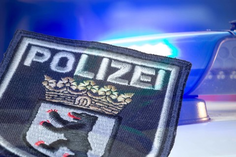 (Photomontage) Symbolic image of a police operation in Berlin: Berlin police emblem in front of