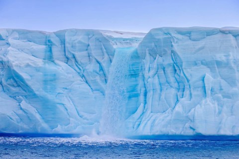 Waterfall at edge of the Brasvellbreen glacier from the ice cap Austfonna debouching into the