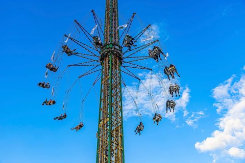 Oktoberfest attraction amusement ride Kettenflieger in front of a white-blue sky, Oktoberfest,