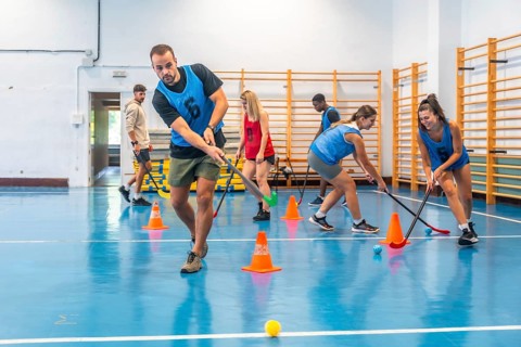 Group of athletes engaged in an intense floorball training session, skillfully dribbling the ball