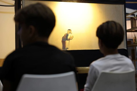 A Syrian puppeteer entertains children at the Damascus International Fair by imitating the role of