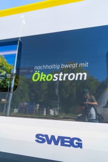 Train with sustainable ecological advertising and reflections on the window, battery Electric train