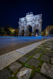The illuminated Siegestor at night, focussed on the road surface, Siegestor, Munich, Germany