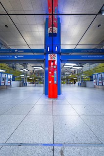 Modern underground station with blue and red elements and SOS station in Munich, Münchner Freiheit,